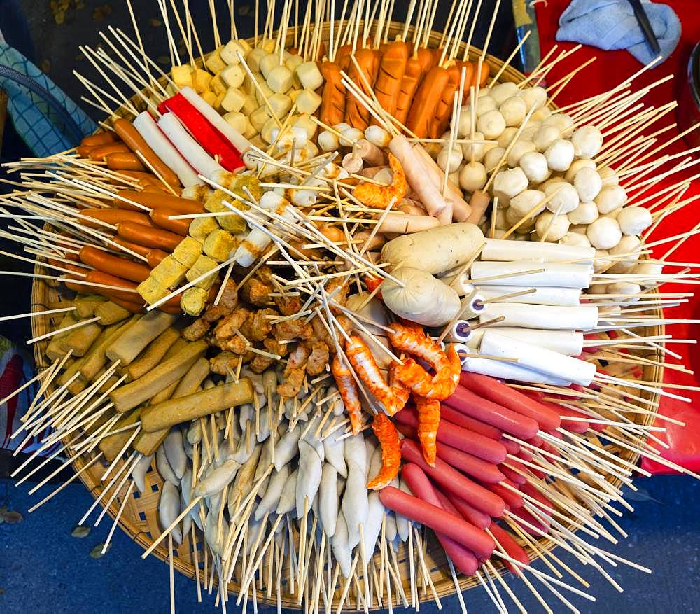 Various skewers with sausage and meat, meatballs, in bamboo basket at a market, Thai cuisine, Thailand, Asia