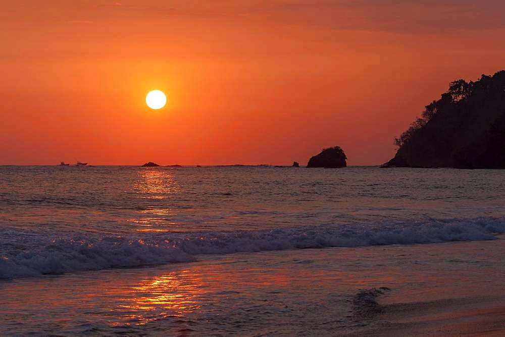 Red glowing sunset over the sea, evening sun, Playa Espadilla, Manuel Antionio National Park, Puntarenas Province, Costa Rica, Central America