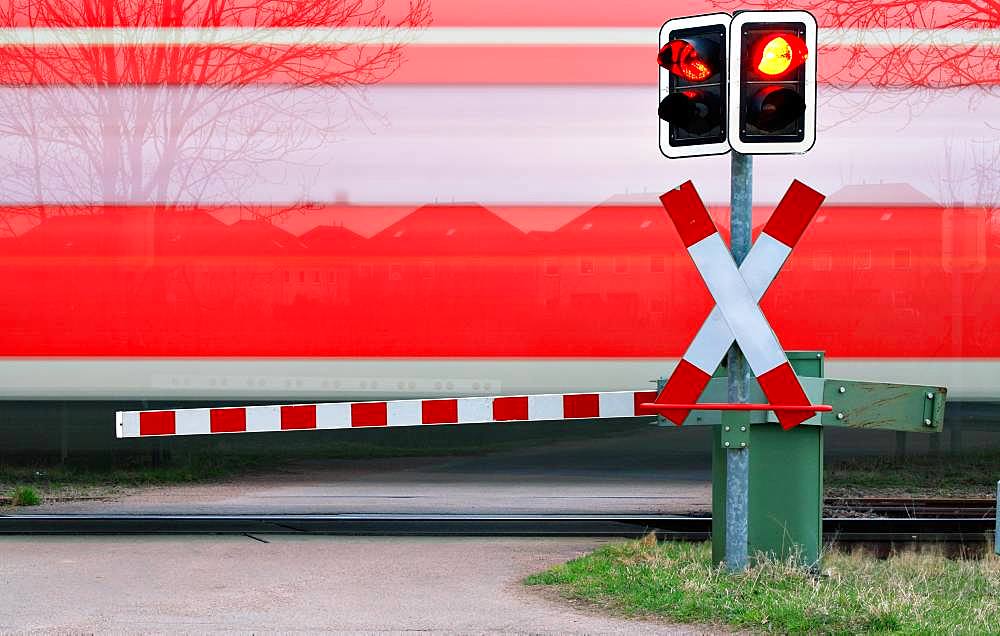 Train passes level crossing with barrier, near Loebejuen, Saxony-Anhalt, Germany, Europe