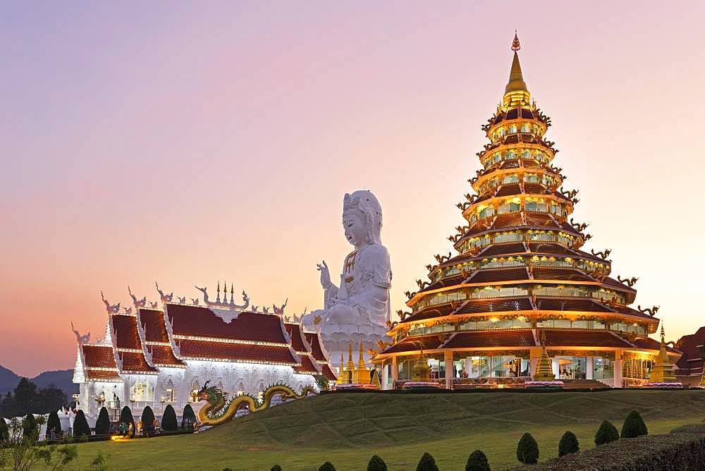 Nine-storey Chinese pagoda and chapel in front of huge Guan Yin statue at sunset, Wat Huay Pla Kang temple, Kuan Yin, Chiang Rai, Northern Thailand, Thailand, Asia