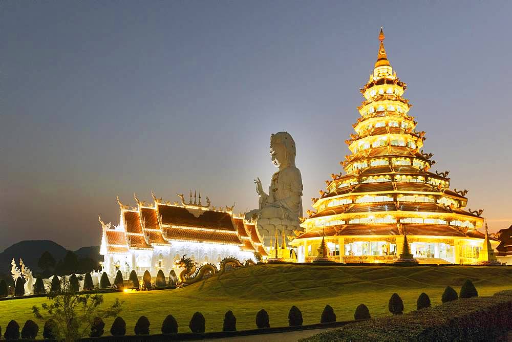 Nine-storey Chinese pagoda and chapel in front of the huge Guan Yin statue at dusk, Wat Huay Pla Kang temple, Kuan Yin, Chiang Rai, Northern Thailand, Thailand, Asia