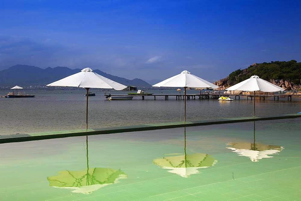 Swimming pool with parasols, Sao Bien holiday resort in the bay of Cam Ranh, South China Sea, Ninh Thuan, Vietnam, Asia