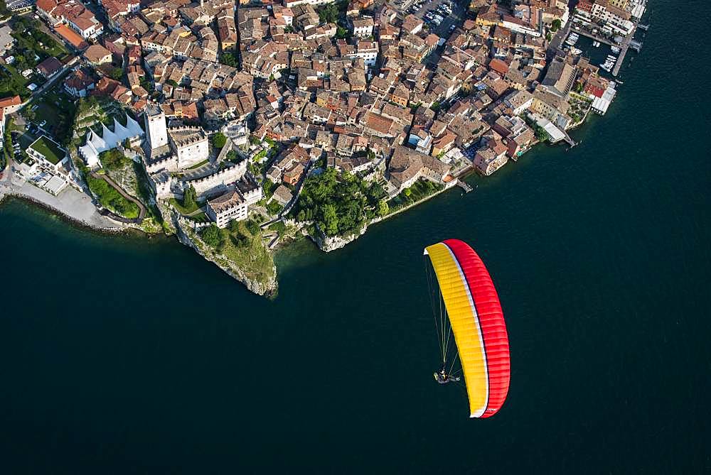 Paraglider over the old town and Castello di Malcesine, Malcesine at Lake Garda, aerial view, Province of Veneto, Italy, Europe