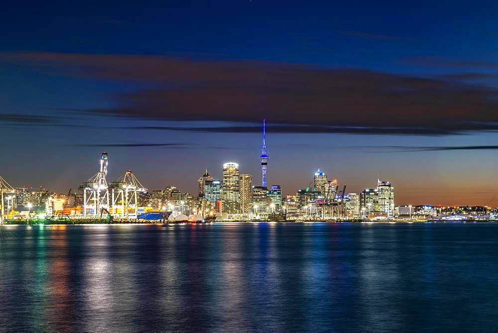 Illuminated skyline of Auckland at sunset, Waitemata Harbour, Sky Tower, Central Business District, Auckland, North Island, New Zealand, Oceania