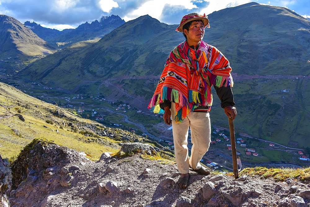 Indio mountain guide with hat and poncho in the Andes, near Cusco, Peru, South America