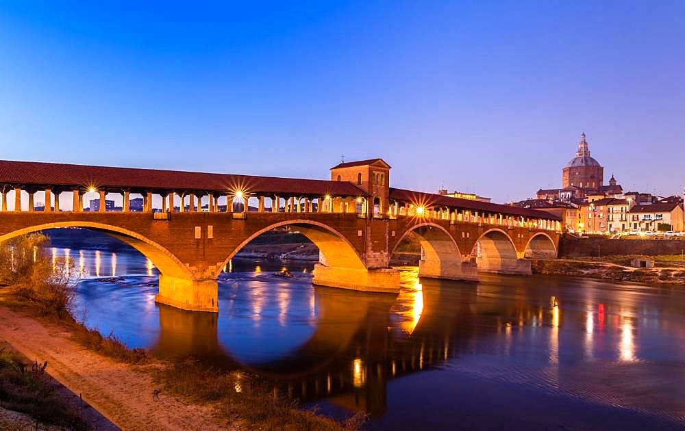 Illuminated bridge Ponte Coperto leads over the river Ticino with cathedral, dusk, Pavia, Lombardy, Italy, Europe