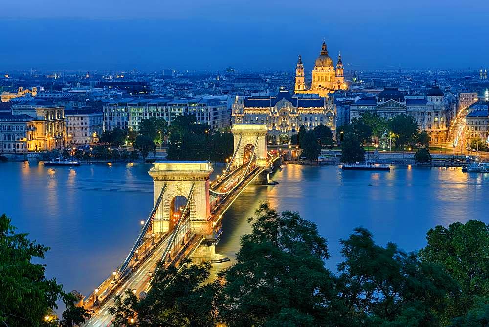 Chain bridge with Gresham Palace and St. Stephen's Basilica, illuminated, dusk, Budapest, Hungary, Europe