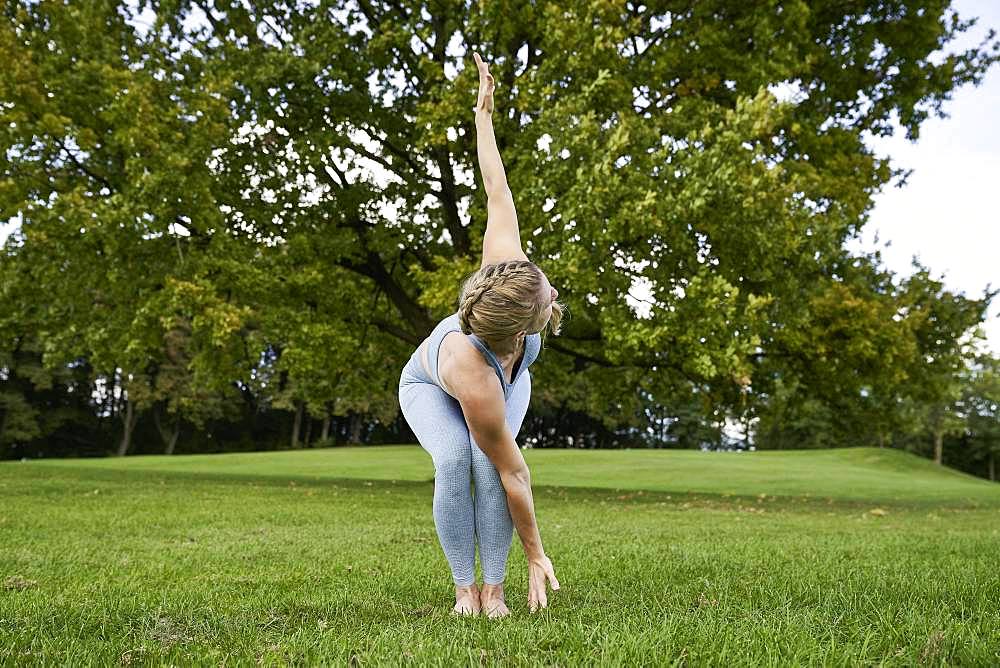 Young woman doing yoga in the park, gymnastics, Olympiapark, Munich, Germany, Europe