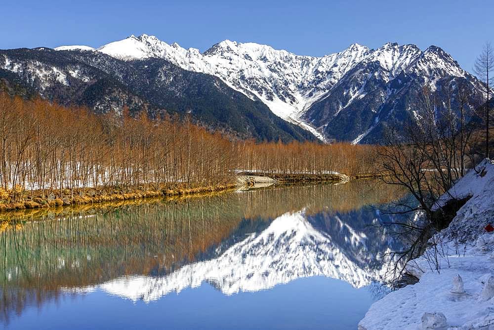 Snow-covered mountains at a lake, Japanese Alps reflected in Taisho Pond, snow-covered Mount Hotaka at the back, Kamikochi, Matsumoto, Nagano, Japan, Asia