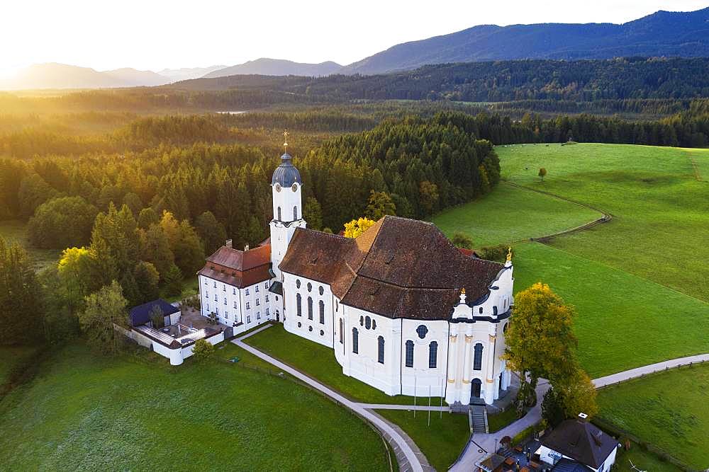 Wieskirche at sunrise, pilgrimage church to the Scourged Saviour on the Wies, Wies, near Steingaden, Pfaffenwinkel, aerial view, Upper Bavaria, Bavaria, Germany, Europe