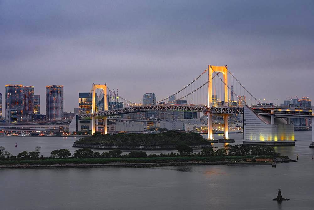 View of skyline with skyscrapers and illuminated Rainbow Bridge in the evening, Odaiba, Tokyo, Japan, Asia