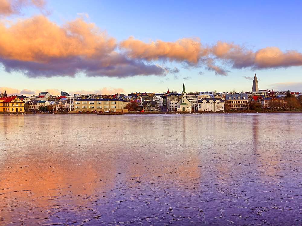 Frozen lake Tjoernin in the city centre, cloud reflection at sunset, Reykjavik, Iceland, Europe