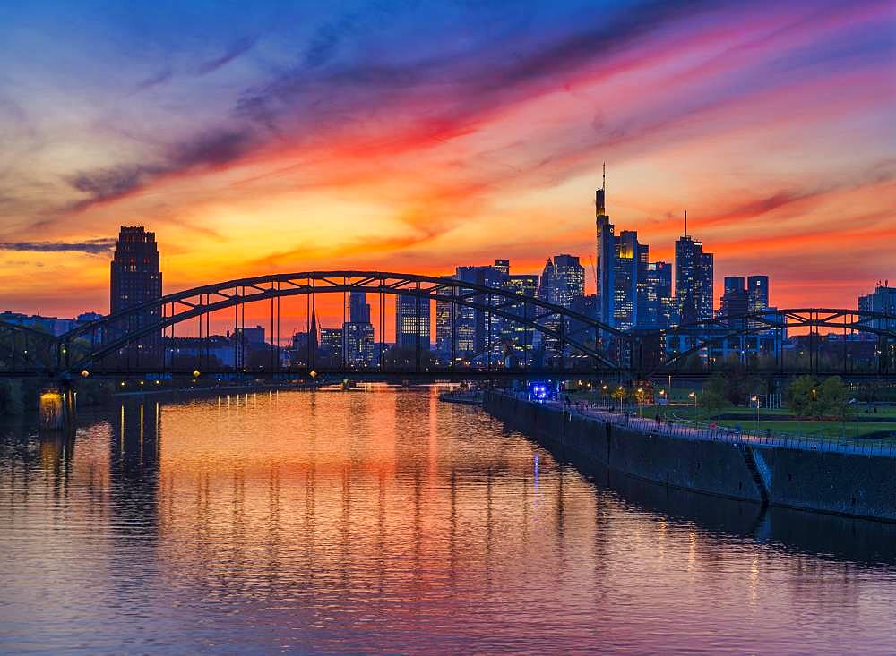 Skyline of Frankfurt in front of sunset with illuminated skyscrapers and reflections in the Main, Frankfurt am Main, Hesse, Germany, Europe