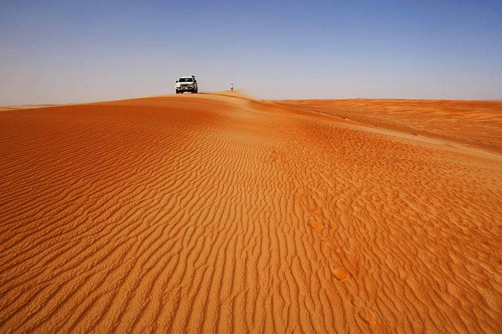 Off-road vehicle and tourist on a sand dunes, desert safari, desert Rimal Wahiba Sands, Oman, Asia