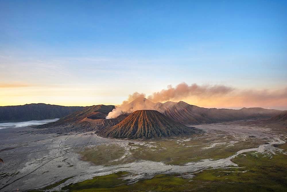 Volcanic landscape at sunrise, smoking volcano Gunung Bromo, with Mt. Batok, Mt. Kursi, Mt. Gunung Semeru, Bromo-Tengger-Semeru National Park, Java, Indonesia, Asia