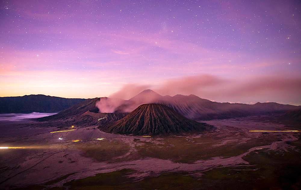 Volcanic landscape at sunrise with starry sky, smoking volcano Gunung Bromo, with Mt. Batok, Mt. Kursi, Mt. Gunung Semeru, National Park Bromo-Tengger-Semeru, Java, Indonesia, Asia