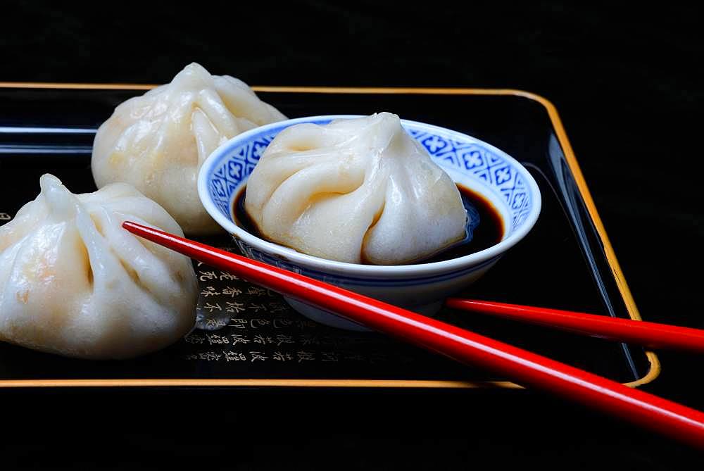 Dim Sum in Chinese bowl with soy sauce, filled dumplings, red chopsticks, Germany, Europe