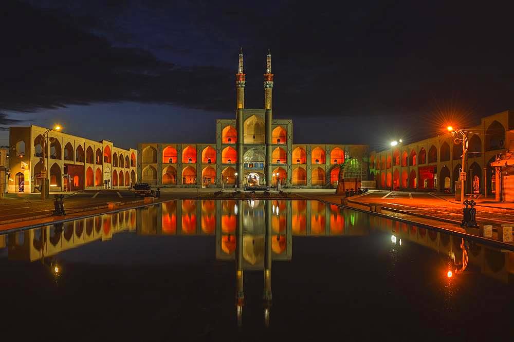 Amir Chaqmaq complex facade illuminated at sunrise and reflecting in a pond, Yzad, Yazd province, Iran, Asia