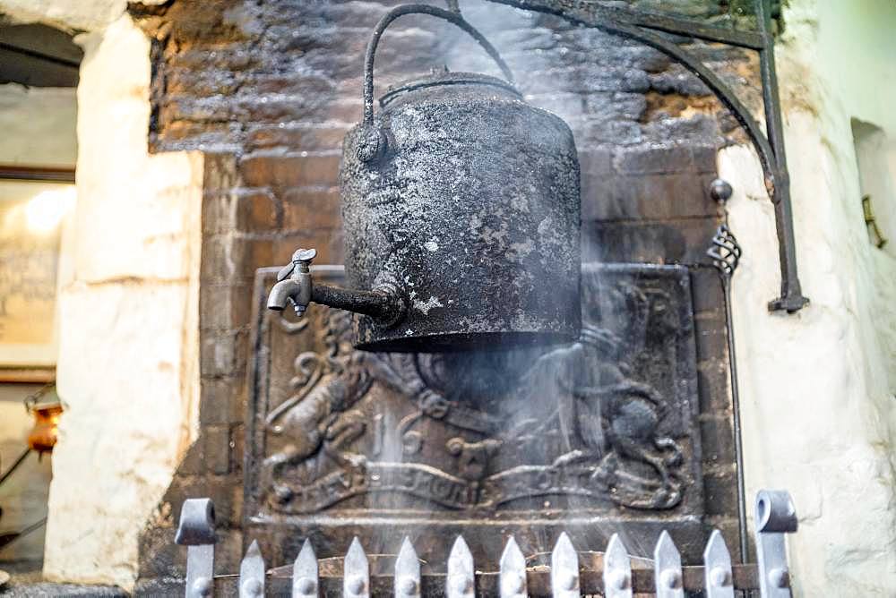 Vintage kettle on fireplace in old English pub, England, Great Britain