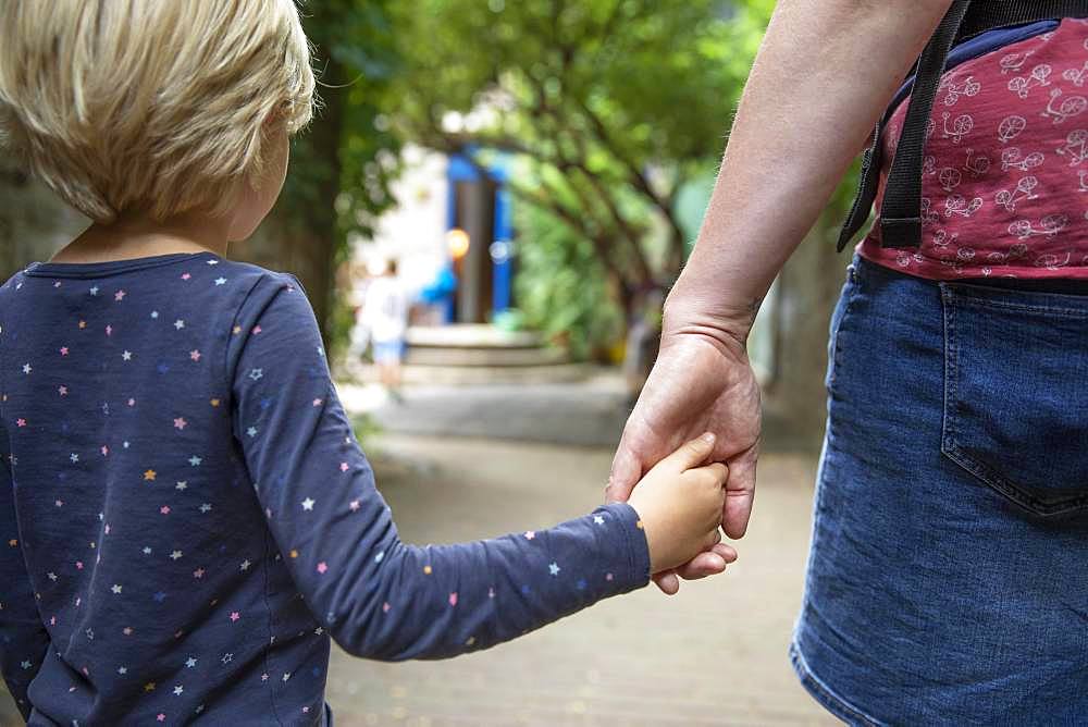 Mother holds daughter by the hand and takes her to kindergarten, Cologne, North Rhine-Westphalia, Germany, Europe