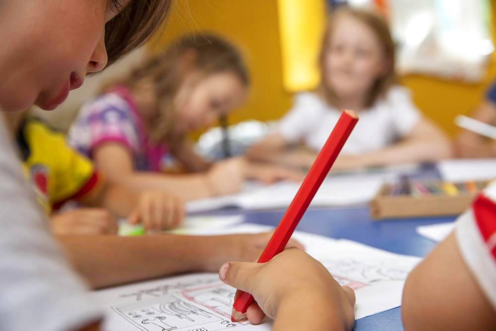 Children painting in kindergarten with crayons, Cologne, North Rhine-Westphalia, Germany, Europe