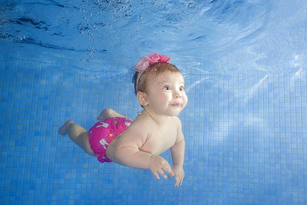 Little baby learning to swim underwater in a swimming pool, Ukraine, Europe