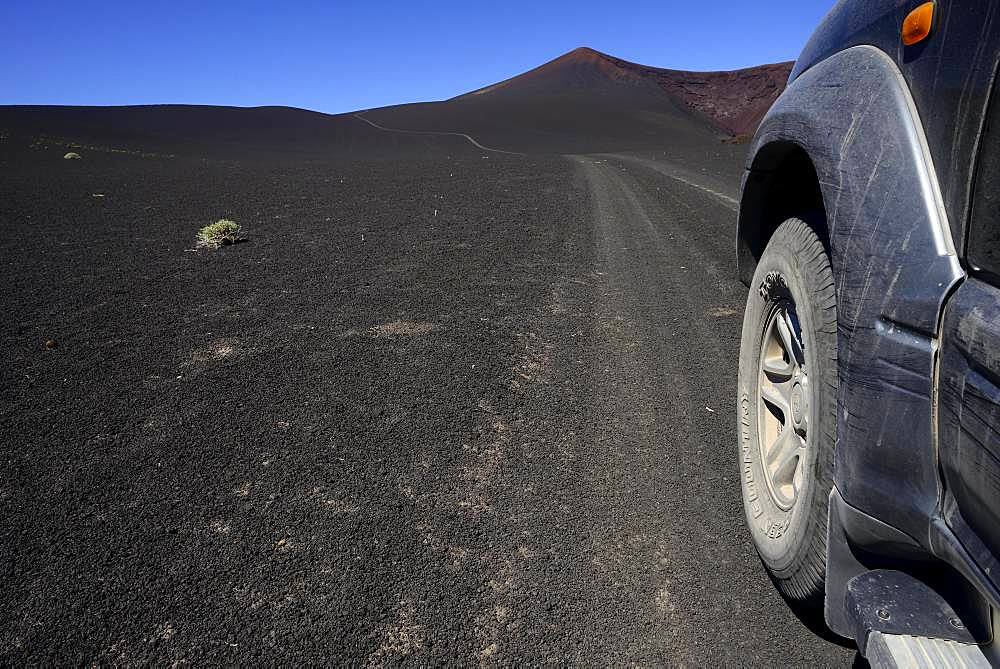 All-terrain vehicle on the road through volcanic lunar landscape, Reserva La Payunia, Mendoza Province, Argentina, South America