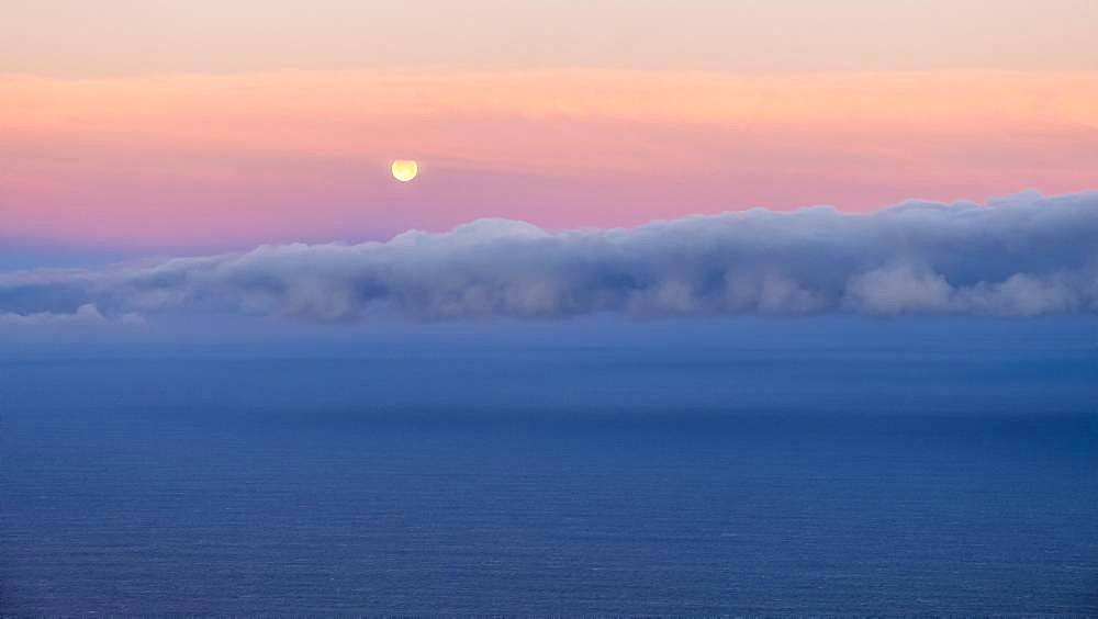Moonset, sunrise mood at the sea, clouds in the sky, Spain, Europe
