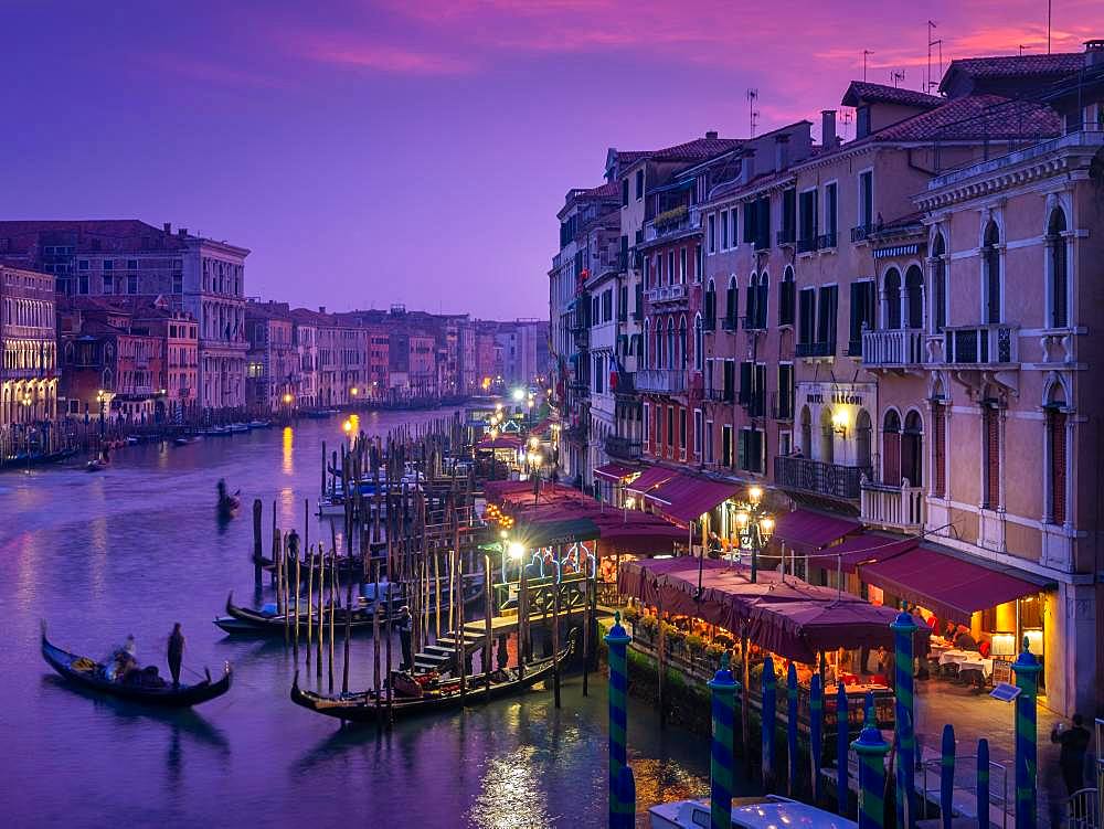 View from the Rialto Bridge on the Canal Grande with gondolier at sunset, Venice, Italy, Europe