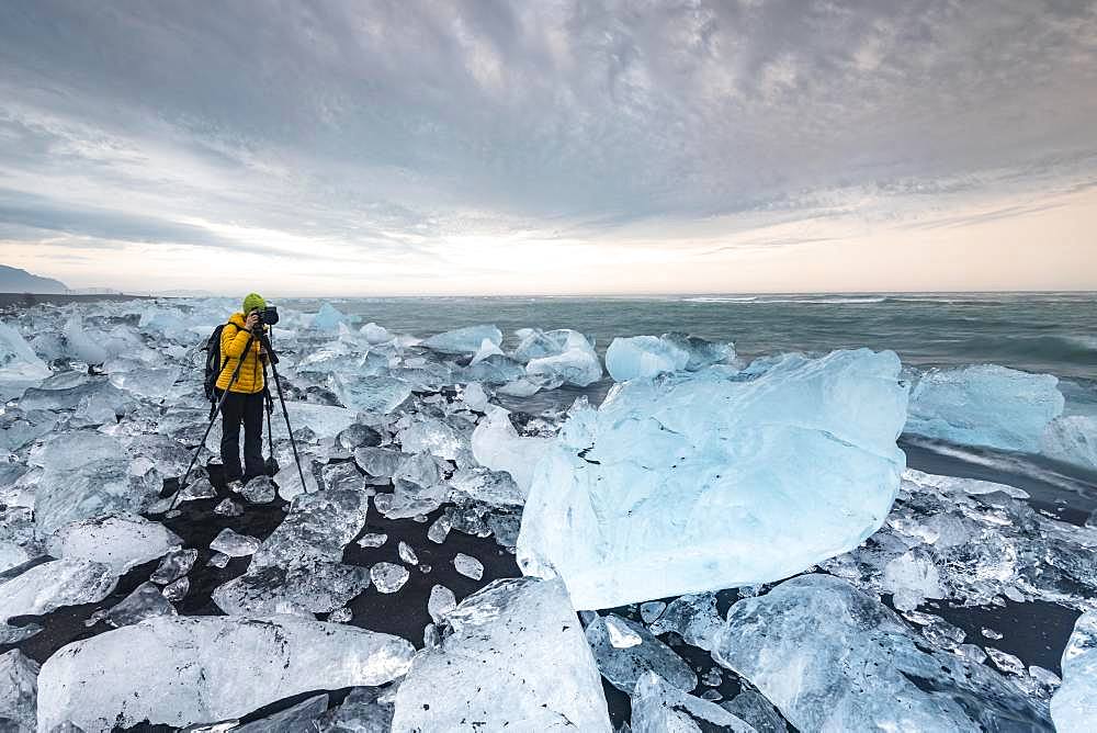 Photographer at Diamond Beach, icebergs at the black lava beach, near glacier lagoon Joekulsarlon, Vatnajoekull National Park, Hornafjoerour, Southern Iceland, Iceland, Europe