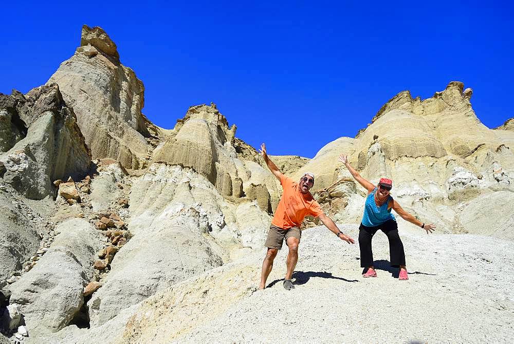 Two tourists at the bizarre rock formations of Cerro Alcazar, Calingasta, San Juan Province, Argentina, South America