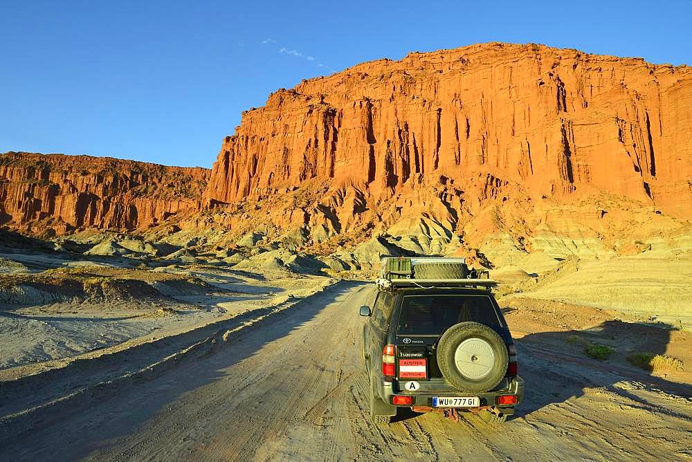 Off-road vehicle, Toyota Land Cruiser on the road in front of a red rock face, Ischigualasto Nature Reserve, San Juan Province, Argentina, South America