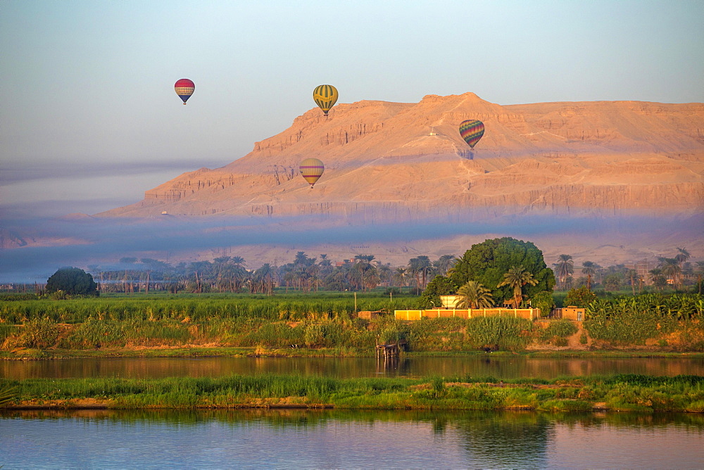 Rising hot air balloons above the temple of Hatshepsut on the banks of the Nile, near Luxor, Egypt, Africa