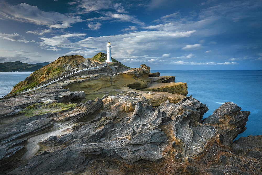 Lighthouse in the evening light on the cliffs of lava rock at Castlepoint, Masterton, Wellington, New Zealand, Oceania