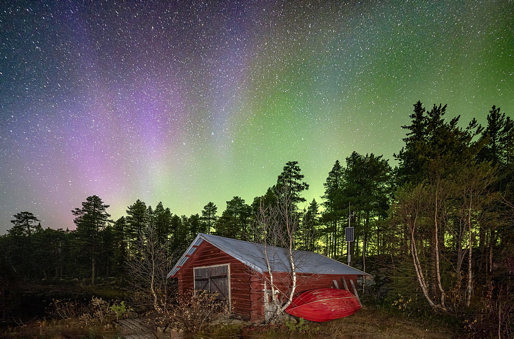 Northern lights above a wooden cabin in a Nordic forest, Jokkmokk, Norrbottens laen, Sweden, Europe