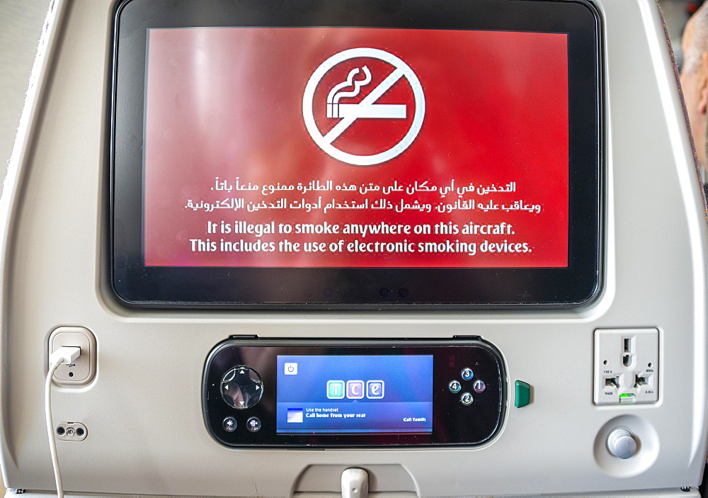 Screen with display smoking ban in Arabic and English on backrest in aircraft, Emirates airline, interior, Dubai, United Arab Emirates, Asia