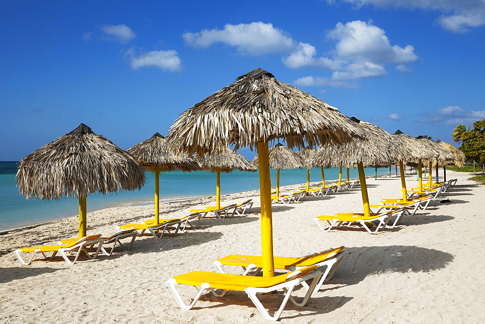 Sunbeds and thatched parasols at the Playa Ancon beach, Trinidad, Cuba, Central America