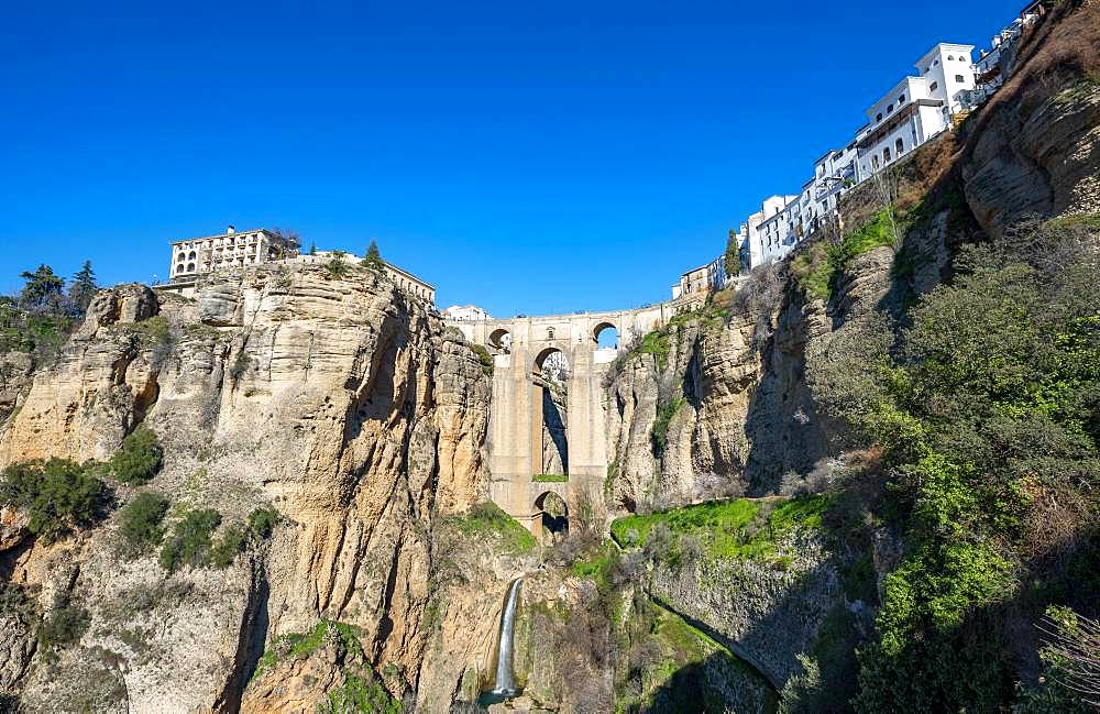 Bridge Puente Nuevo with waterfall at steep cliffs, Tajo gorge and river Rio Guadalevin, Ronda, province of Malaga, Andalusia, Spain, Europe