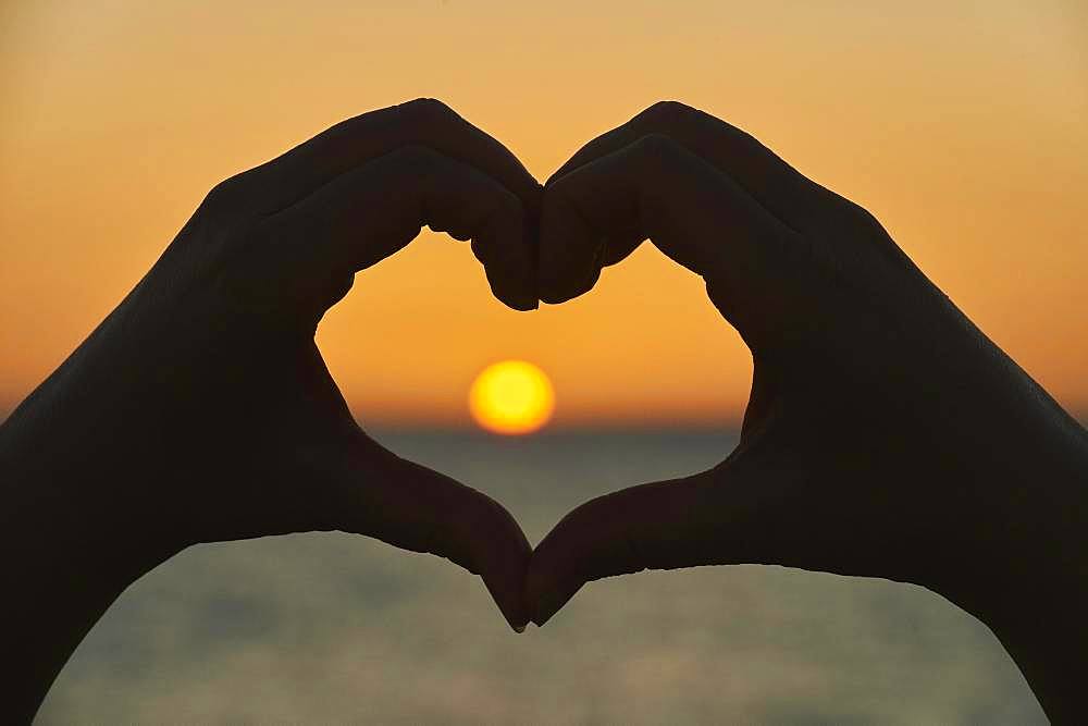 Hands forming a heart at sunset, Fuerteventura, Province of Las Palmas, Canary Islands, Spain, Europe