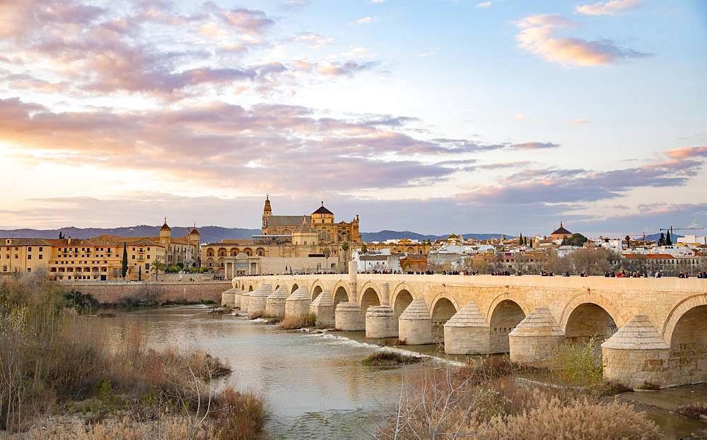 Sunset, Puente Romano, Roman bridge over Rio Guadalquivir, behind Mezquita, Catedral de Cordoba, Cordoba, Andalusia, Spain, Europe