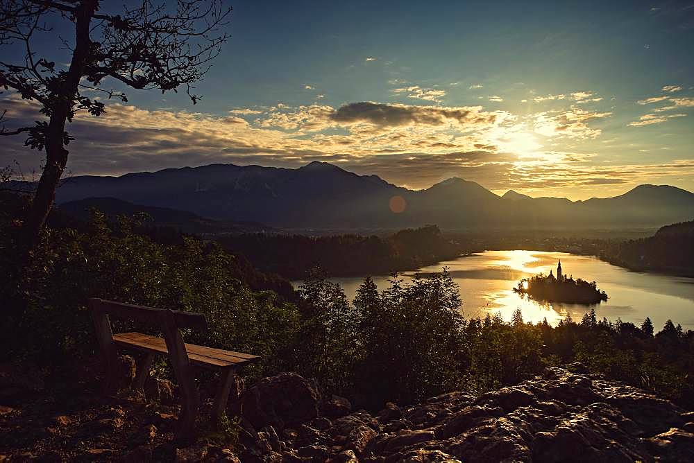 A bench for lovers with a view of the rising sun on Lake Bled, Bled, Slovenia, Europe