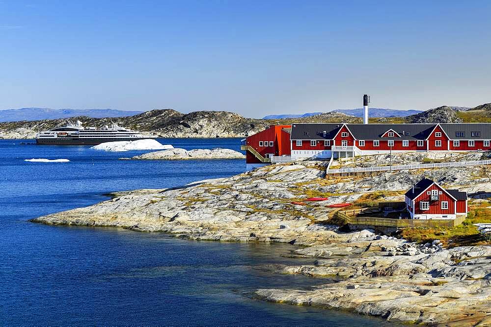 Colourful houses with view into Disko Bay to the cruise ship Ponant, Ilulissat, West Greenland, Greenland, North America