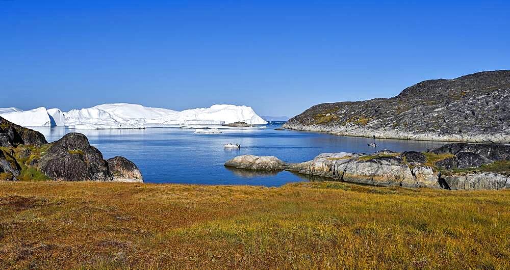 Fishermen with boat in front of gigantic icebergs, UNESCO World Natural Heritage, Ilulissat, Disko Bay, West Greenland, Greenland, North America