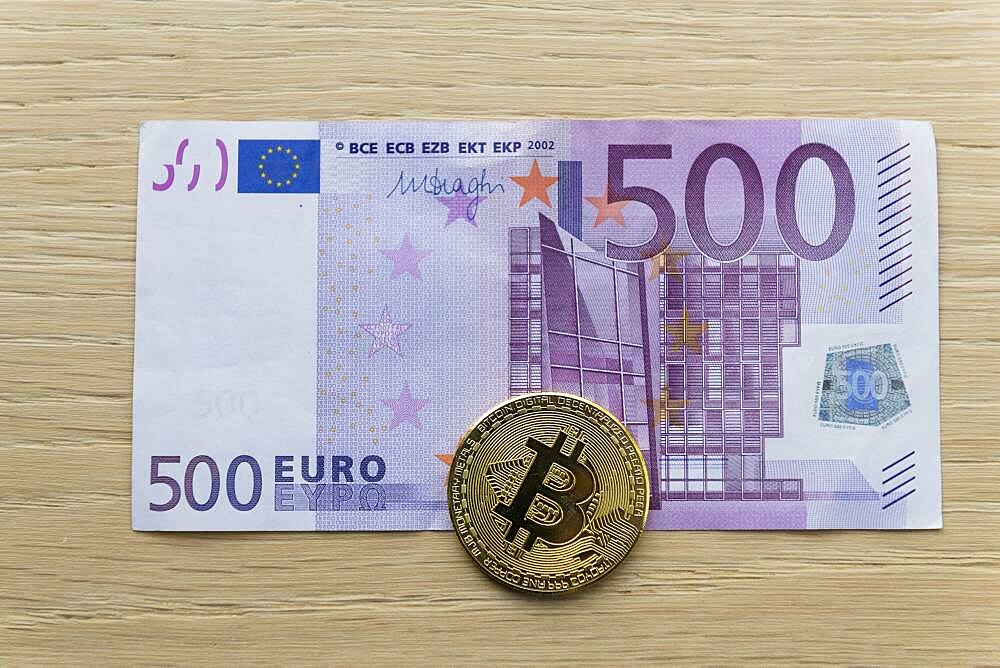 Symbol image digital currency, physical coin Bitcoin, on euro banknote