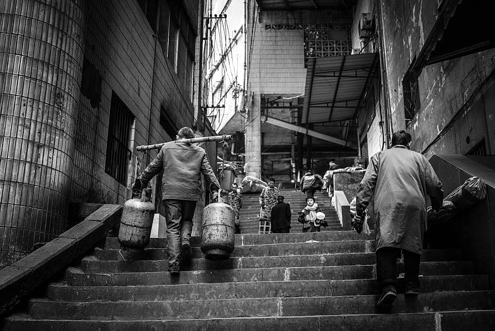 Bang-bang carriers in a market at the port of Chongqing, the carriers are like a caste of their own, carrying loads for the traders for little money, mostly immigrant workers from rural areas, Chongqing, China, Asia