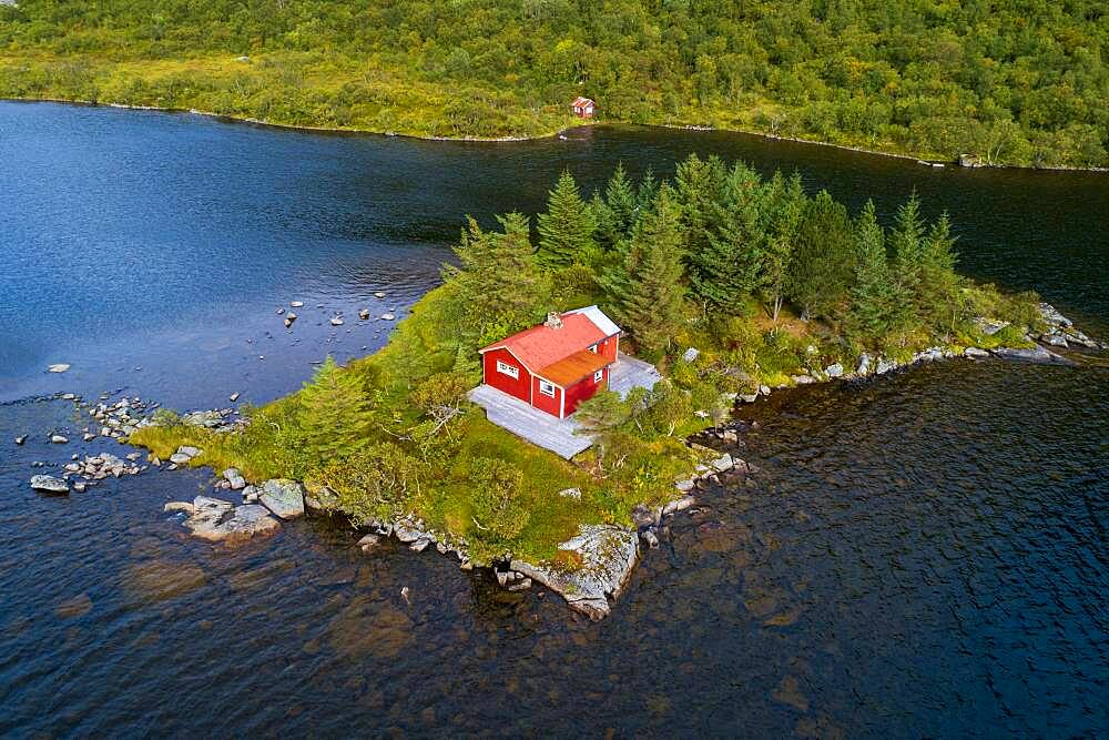 Red wooden cabin on a small island in a lake, Vestvagoy, Nordland, Lofoten, Norway, Europe