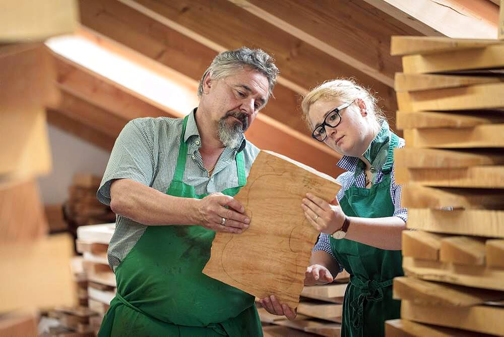 Employee and master violin maker Rainer W. Leonhardt choose wood in the warehouse, Mittenwald, Bavaria, Germany, Europe