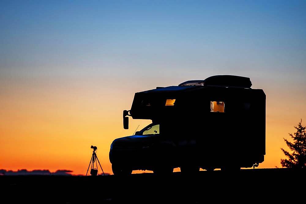 Silo hut motorhome and photo tripod with camera bag and camera at dusk, Nordland, Norway, Europe