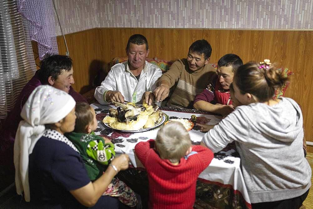 Spai Bashakhan, head of a nomadic family in the Altai mountains, dinner together in the winter quarters, Olgii province, Mongolia, Asia