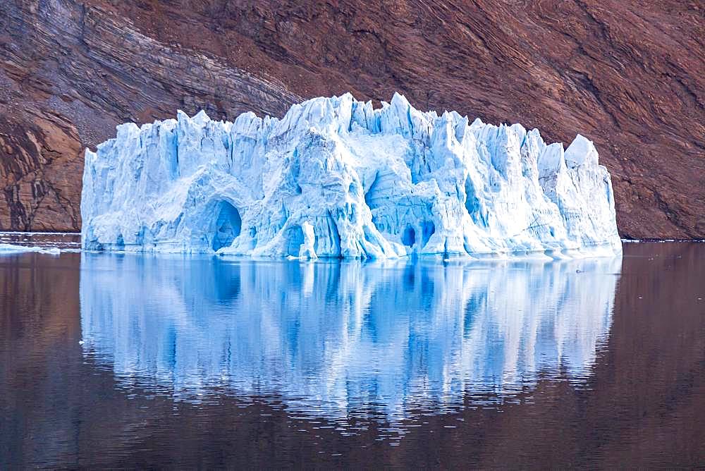 Iceberg in front of rock in fjord, Kaiser-Franz-Joseph-Fjord, east coast Greenland, Denmark, Europe